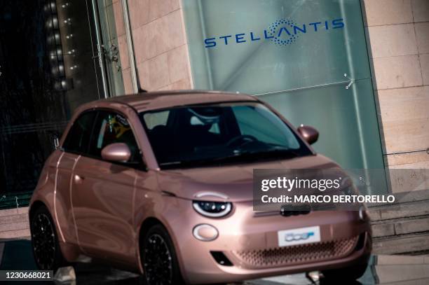 Picture taken on January 19, 2021 shows the Prima 500 electric car displayed in front of logo of Stellantis, the company forged in mega-merger of...