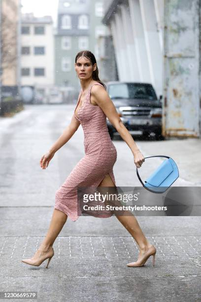 Actress and model Rebecca Kunikowski wearing a midi length pink dress with pattern by Lana Mueller, nude pumps by Lana Mueller and a light blue bag...