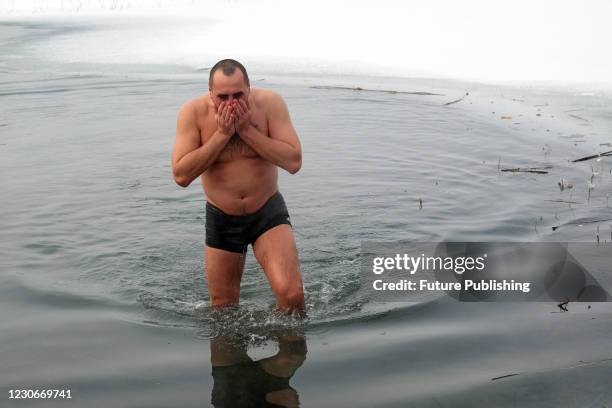 Man emerges from Lake Chyste on Epiphany, Sievierodonetsk, Luhansk Region, eastern Ukraine. Devotees believe that water on this day has healing...