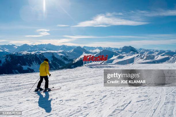 Leisure skier makes his run past a Kitzbuehel sign in front of the panorama of Tyrolien Alps, prior to the 81st Hahnenkamm race of the men's alpine...