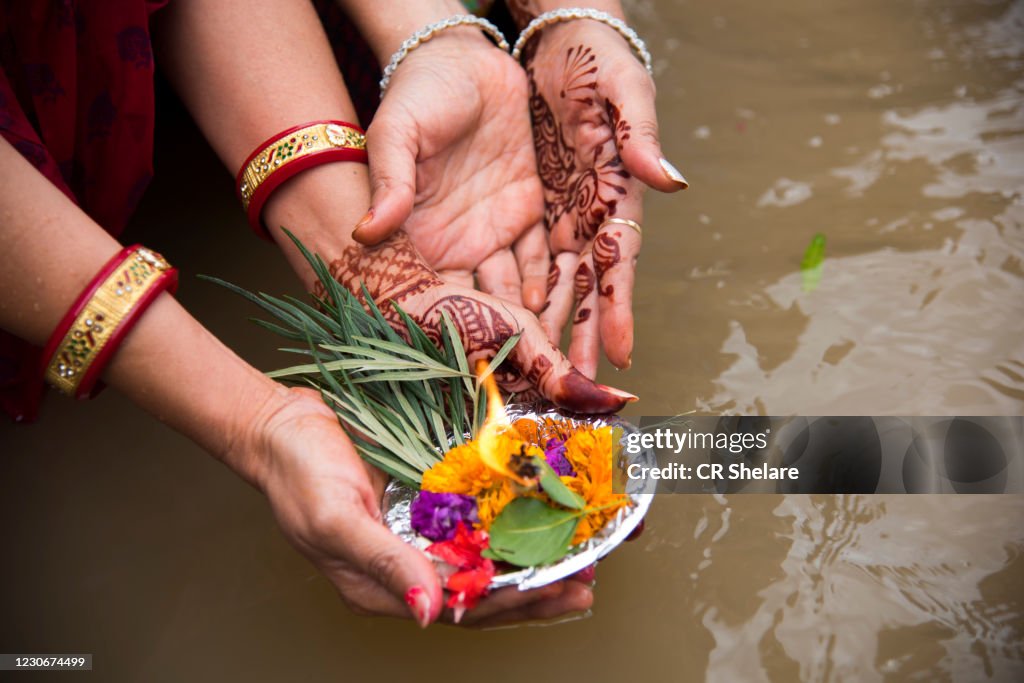 Woman hands offering diyas Oil Lamp to river