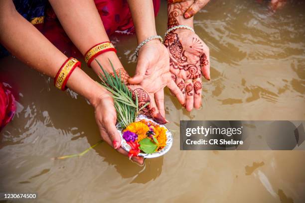 woman hands offering diyas oil lamp to river - aarti stock pictures, royalty-free photos & images