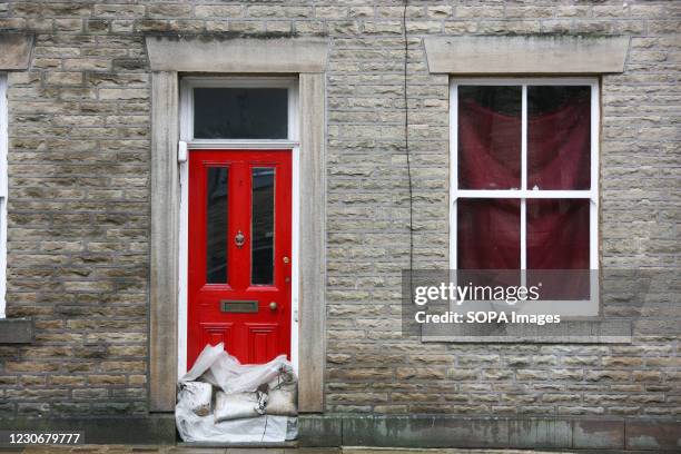 Sandbags are piled up against the door of a house in Hebden Bridge as residents prepare for Storm Christoph. Residents are preparing for potential...