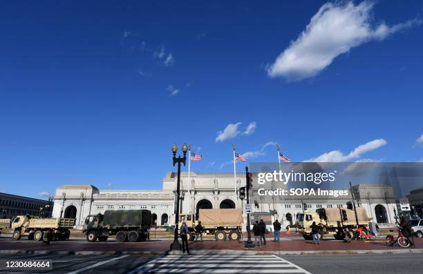 National Guard soldiers in military vehicles drive past the Union Station the day before the inauguration ceremonies for President-elect Joe Biden....