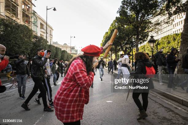 Young female protester raises a loaf of bread as she is suffocated by the pepper spray used by the security forces during an anti-government...