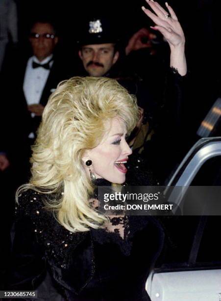 Singer Dolly Parton waves to the crowd gathered across the street from Radio City Music Hall 01 March 1994. Parton was on hand to attend the 36th...