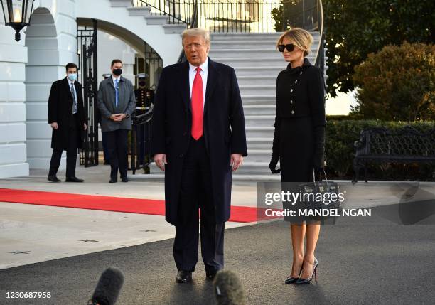 Outgoing US President Donald Trump and First Lady Melania Trump talk to the press as they depart the White House in Washington, DC, on January 20,...