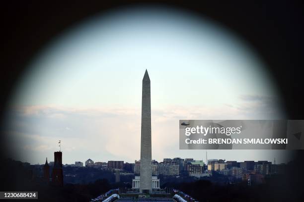 Marine One with US President Donald Trump and First Lady Melania Trump passes the Washington Monument as it departs the White House in Washington,...