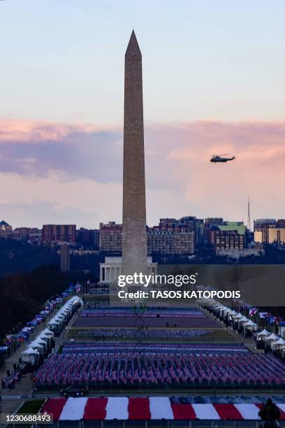 Marine One with US President Donald Trump and First Lady Melania Trump passes the Washington Monument as it departs the White House in Washington,...