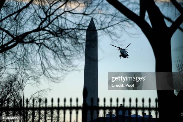 Marine One with President Donald Trump aboard flies past the Washington Monument on January 20, 2021 in Washington, DC. President Donald Trump is...