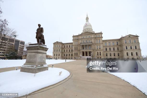 Michigan state police patrol the grounds outside the Michigan state capitol building on January 20, 2021 in Lansing, Michigan. State capitols across...