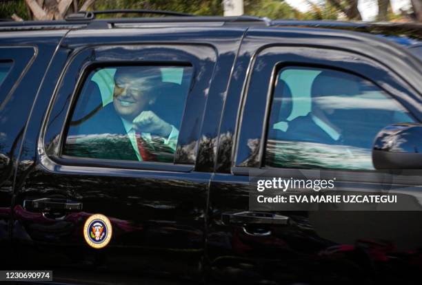 President Donald Trump pumps his fist as his motorcade arrives at Mar-a-Lago in Palm Beach, Florida, on January 20, 2021.