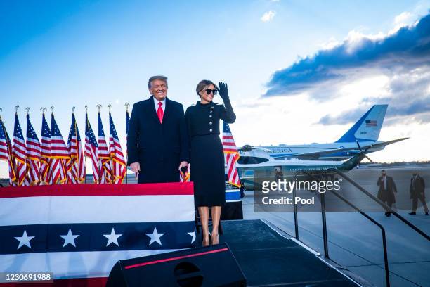 President Donald Trump and First Lady Melania Trump acknowledge supporters at Joint Base Andrews before boarding Air Force One for his last time as...