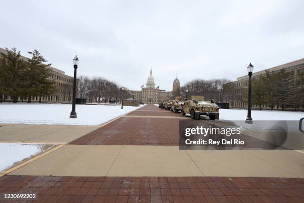 Michigan National Guard trucks are parked outside the Michigan State Capitol building on January 20, 2021 in Lansing, Michigan. State capitols across...