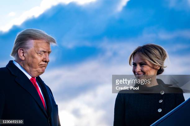 President Donald Trump and First Lady Melania Trump pause while speaking to supporters at Joint Base Andrews before boarding Air Force One for his...