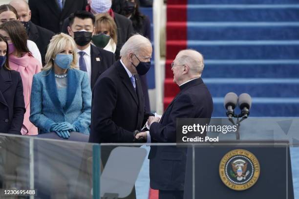 Father Leo ODonovan talks to President-elect Joe Biden after delivering the invocation during the 59th inaugural ceremony on the West Front of the...