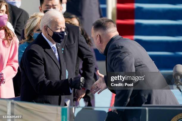 Garth Brooks shakes President Joe Bidens hand as he arrives to sing Amazing Grace during the the 59th inaugural ceremony on the West Front of the...