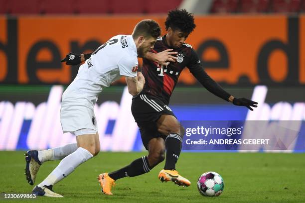 Augsburg's Dutch defender Jeffrey Gouweleeuw and Bayern Munich's French forward Kingsley Coman vie for the ball during the German first division...