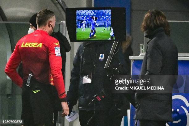 Italian referee Paolo Valeri checks the Video Assistant Referee next to Juventus' Italian coach Andrea Pirlo prior to give a penalty to Napoli during...