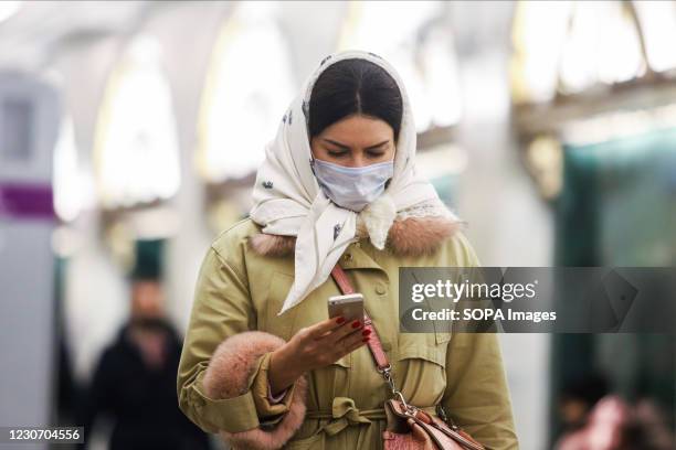 Woman wearing a face mask as a protective measure against the spread of coronavirus walks around the subway station amid coronavirus crisis. Russia...