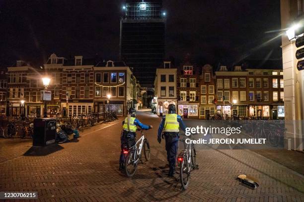 Law enforcement officers walk through the center of Utrecht, on January 21, 2021 during the Covid-19 pandemic. - The Netherlands plans to impose a...