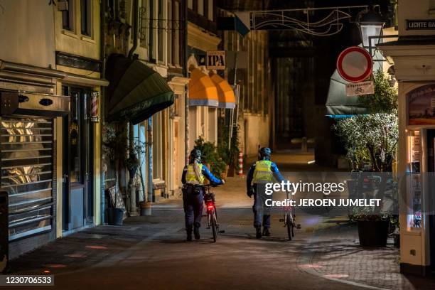 Law enforcement officers walk through the center of Utrecht, on January 21, 2021 during the Covid-19 pandemic. - The Netherlands plans to impose a...