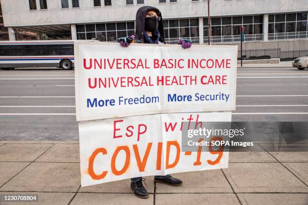 Individual demonstrator holds sign asking for Universal Basic Income and Universal Healthcare for all. Activist groups in Columbus came together to...