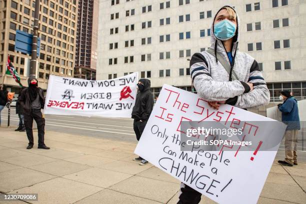 Demonstrators hold their sign and banner in front of the Columbus City Hall. Activist groups in Columbus came together to form the 'United Front...