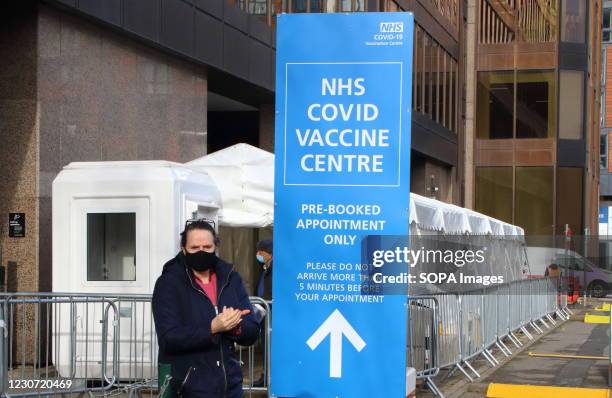 Woman wearing a face facemask checks into the vaccination centre. A steady stream of elderly people with pre-booked appointments at the new Covid-19...