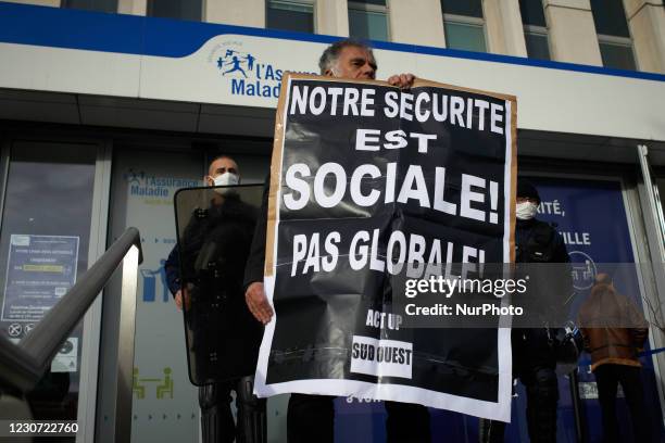 Protester holds a placard reading 'Our security is social, not global' in front of the Social Security building. Culture workers and activists...