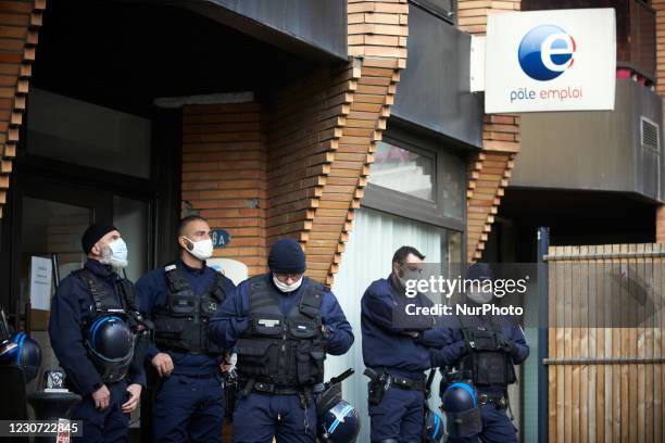 Riot policemen stand guard in front of a Pole Emploi agency . Culture workers and activists organized a performance in the streets of Toulouse to...