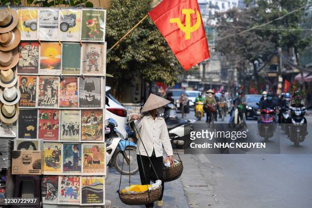 Vendor walks under a Communist Party flag ahead of the upcoming 13th National Congress of the Communist Party of Vietnam on a street in Hanoi on...