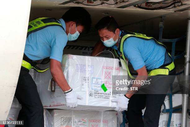 Workers unload cartons of a Covid-19 coronavirus vaccine being delivered from India to Myanmar, at Yangon International Airport in Yangon on January...
