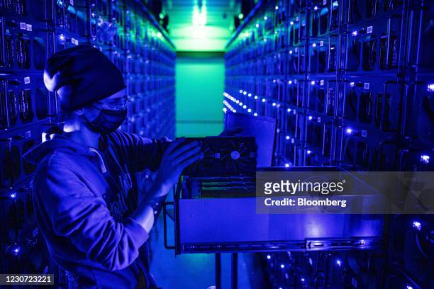 An engineer inspects a Sapphire Technology Ltd. AMD graphics processing unit at the Evobits crypto farm in Cluj-Napoca, Romania, on Wednesday, Jan....