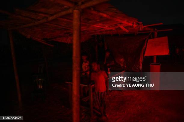 This photo taken on January 11, 2021 shows Chin children playing next to their house at night in Bethel village in Hmawbi, on the outskirts of...