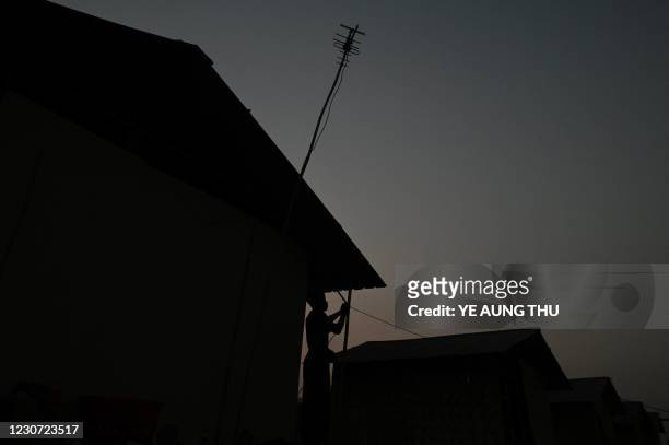 This photo taken on January 11, 2021 shows a Chin man setting up electricity for his house in Bethel village in Hmawbi, on the outskirts of Yangon,...