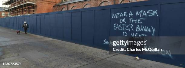 Panoramic view of graffiti which declares Wear a mask or the Easter bunny is next on December 30, 2020 in Belfast, Northern Ireland. The province...
