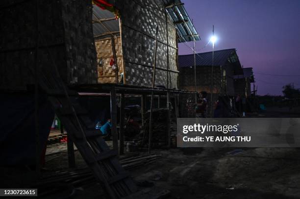 This photo taken on January 11, 2021 shows Chin woman standing next to her home in Bethel village in Hmawbi, on the outskirts of Yangon, where...