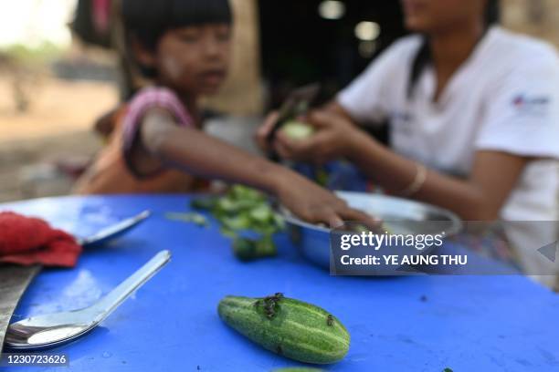 This photo taken on January 11, 2021 shows a Chin family preparing to cook a meal in Bethel village in Hmawbi, on the outskirts of Yangon, where...