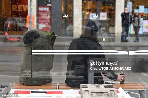 Man drinks beer at a bus station shelter at Berlin's Friedrichstrasse on January 22 during the ongoing novel coronavirus pandemic.