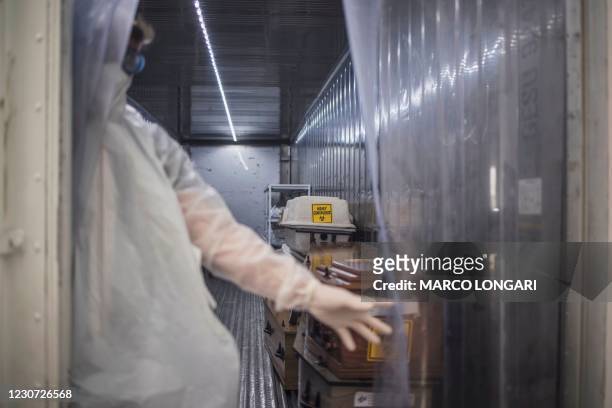 Morgue attendant at the Johannesburg branch of the South African funeral and burial services company Avbob keeps the curtain open from inside a...
