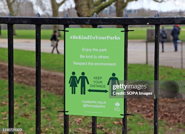 Social distancing sign on the railings outside Hyde Park. England remains under lockdown as the Prime Minster Boris Johnson refuses to rule out that...