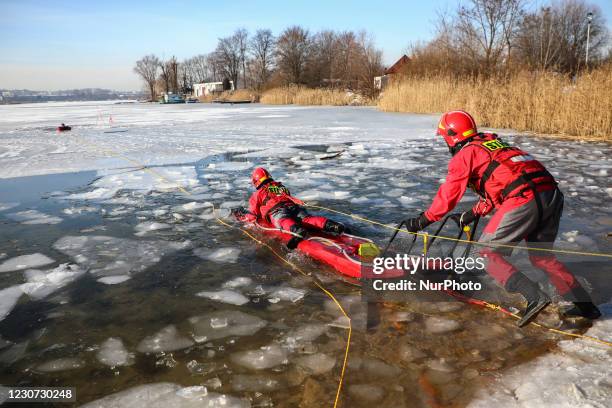 Firefighters wearing PPE conduct an ice rescue training exercise on a frozen Bagry lake in Krakow, Poland.January 21, 2021. Participating...