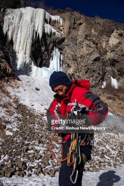 Jan. 16, 2021 -- Huang Huang checks his climbing tools at a canyon on the outskirts of Urumqi, northwest China's Xinjiang Uygur Autonomous Region, on...