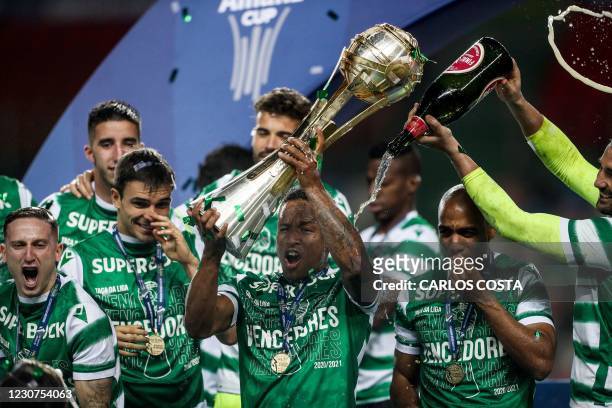 Sporting's Cape Verdean forward Jovane Cabral holds up the winner's trophy as he celebrates with teammates winning the Portuguese Taca da Liga final...