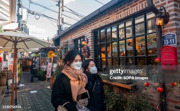 Couple wearing face masks as a preventive measure against the spread of Covid-19 walk at a quiet Ikseon-dong village. Ikseon-dong village is a...