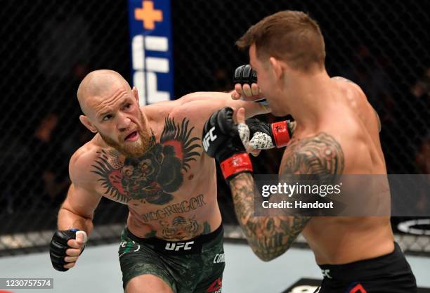 In this handout image provided by the UFC, Conor McGregor of Ireland punches Dustin Poirier in a lightweight fight during the UFC 257 event inside...