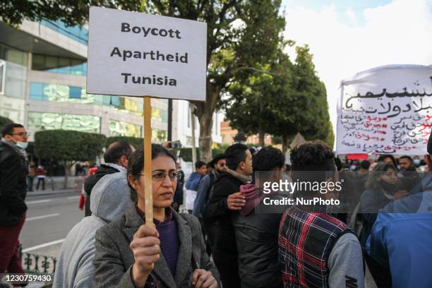 Female protester holds a placard that reads, boycott apartheid Tunisia as she took part in demonstration held in the capital Tunis, to call for the...