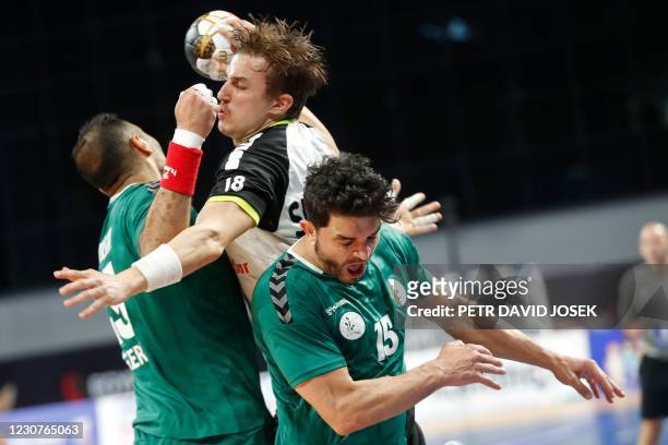 Switzerland's left back Roman Sidorowicz jumps to shoot past Algeria's right winger Redouane Saker during the 2021 World Men's Handball Championship...