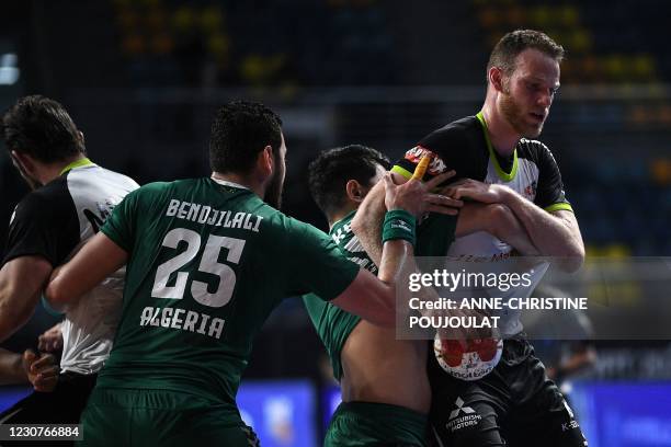 Switzerland's left back Roman Sidorowicz is challenged by an Algerian defender during the 2021 World Men's Handball Championship match between Group...